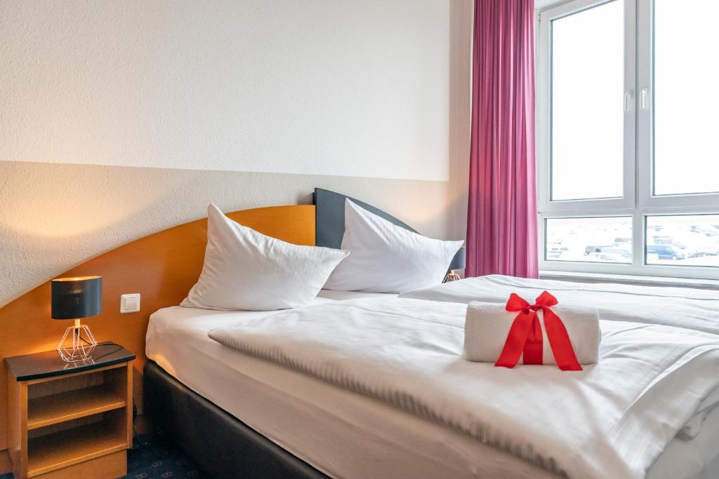 WiedemarHotel Belmondo Leipzig Airport的酒店客房,配有一张带弓的床铺