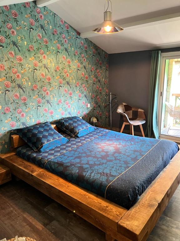 库隆Relais de la Venise verte的卧室内的一张床位,卧室内拥有花卉墙