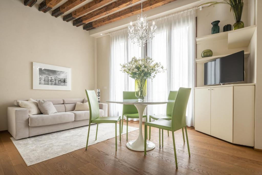 威尼斯Santa Fosca Design Apartment R&R的客厅配有桌子和绿色椅子