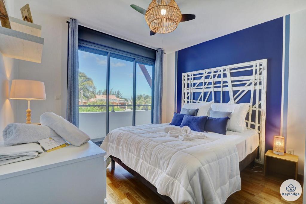 埃唐萨莱莱班海滩Ocean Cottage 3 étoiles - 50 m2 - Etang Salé Les Bains的卧室设有白色的床和大窗户