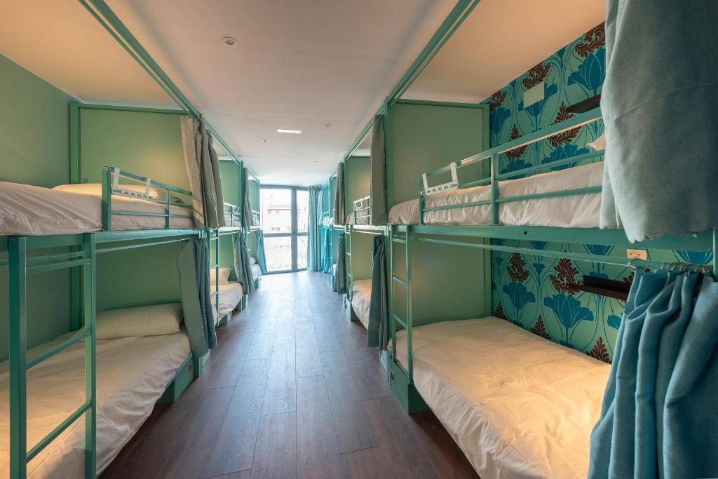 巴塞罗那Hostelle - Women only hostel Barcelona的一间设有双层床的房间的走廊