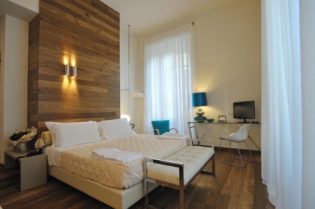 佛罗伦萨迪莫拉迪戈里安吉利奢华住宿加早餐旅馆的一间卧室配有一张床、一张书桌和一台电视