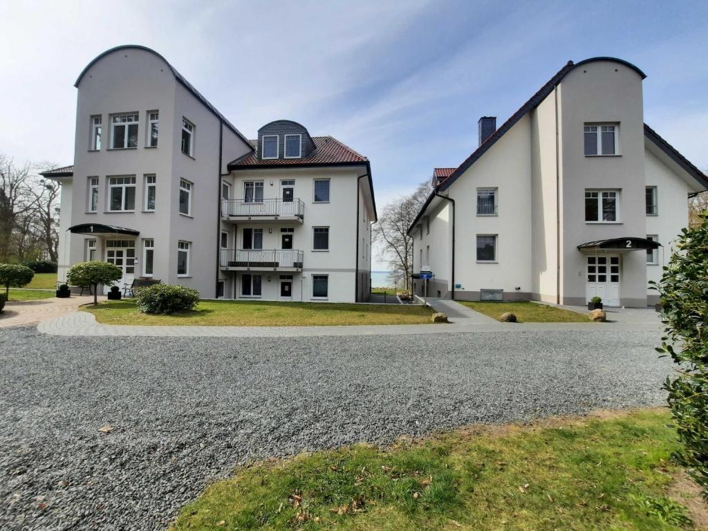 科尔萍湖Haus am Kölpinsee FW Seejuwel Objekt ID 13833-4的砾石车道上两栋白色大房子