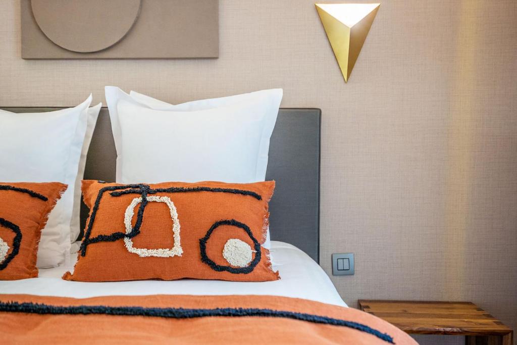 巴黎Yuna Les Halles - Serviced Apartments的一张带橙色和白色枕头的床