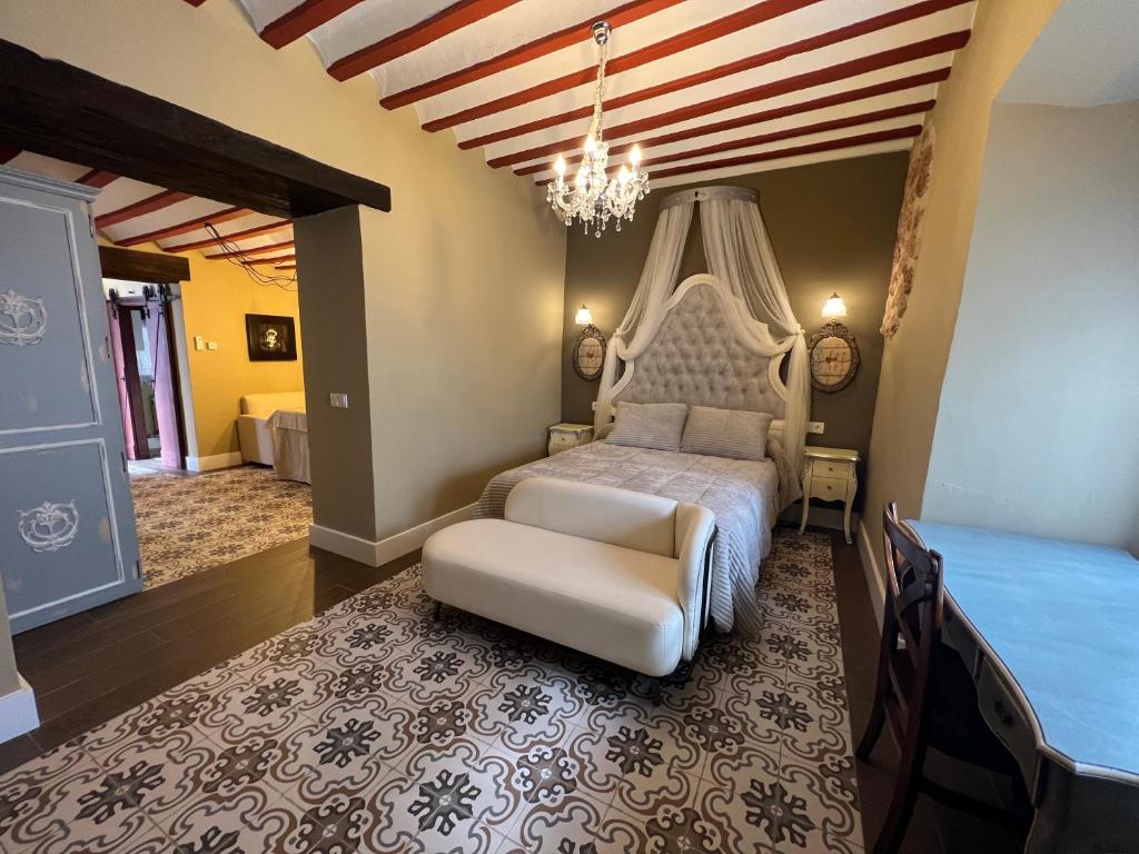 阿尔玛格鲁Retiro del Teatro Almagro的一间卧室配有一张床、一把椅子和一个吊灯。