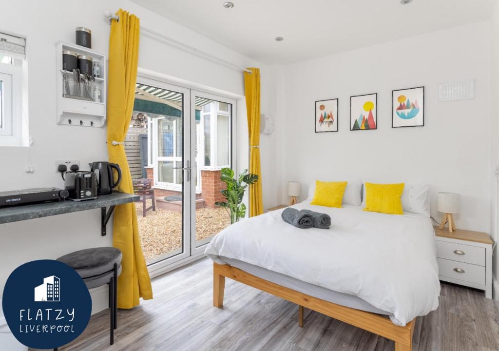 利物浦Flatzy - Charming Garden Annexe in Aigburth with Kitchenette的一间卧室配有一张带黄色窗帘的大床