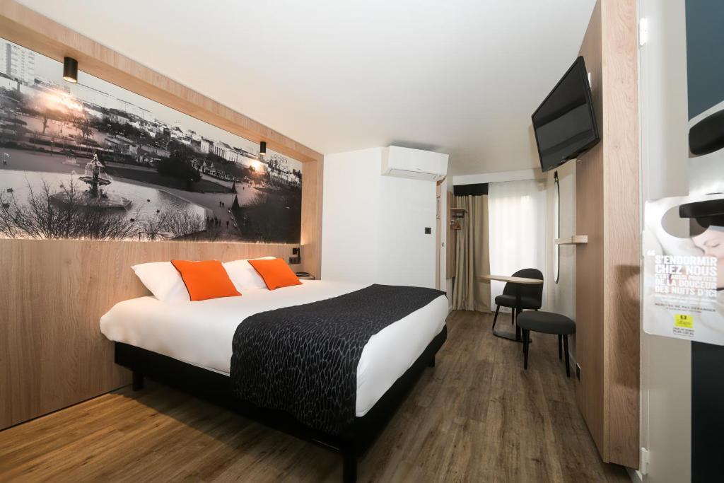 昂热Logis Hôtel Angers Sud的一间酒店客房,配有一张床和一台电视