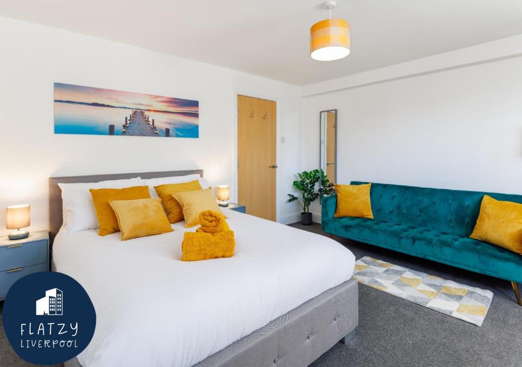 利物浦FLATZY - Modern Apartment Close to Football Stadiums的卧室配有白色的床和蓝色的沙发