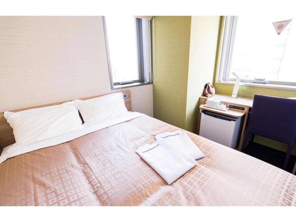 成田Meet Inn Narita - Vacation STAY 43769v的酒店客房,配有白色床单和窗户。
