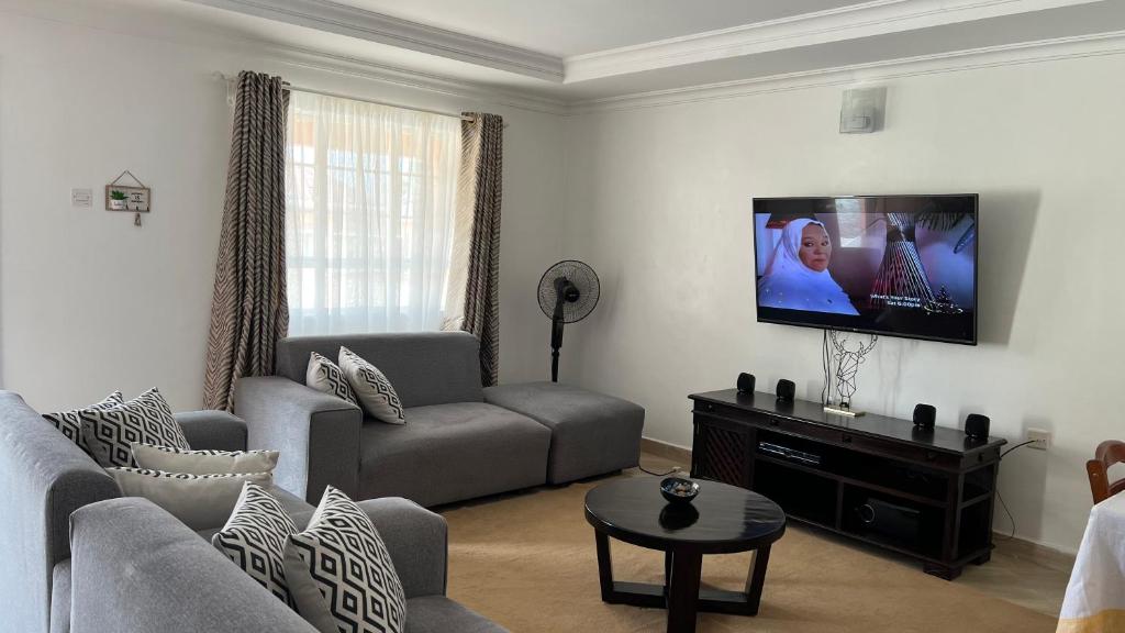 BondoDala Luxury Home- Bondo的带沙发和平面电视的客厅