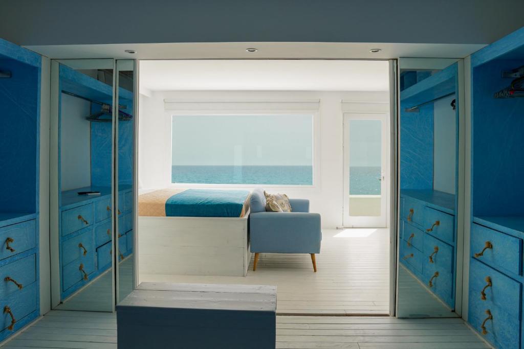 卡尔扎迈纳Boathouse的卧室配有床、椅子和窗户。