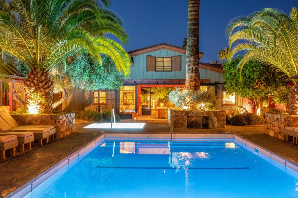 棕榈泉斯派罗木屋度假酒店的一座带游泳池和棕榈树的房子