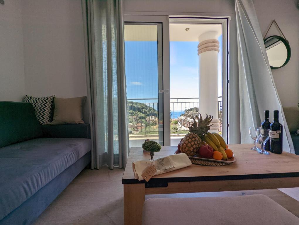 帕尔加Natura Luxury Suites Parga的客厅配有带水果和葡萄酒瓶的桌子