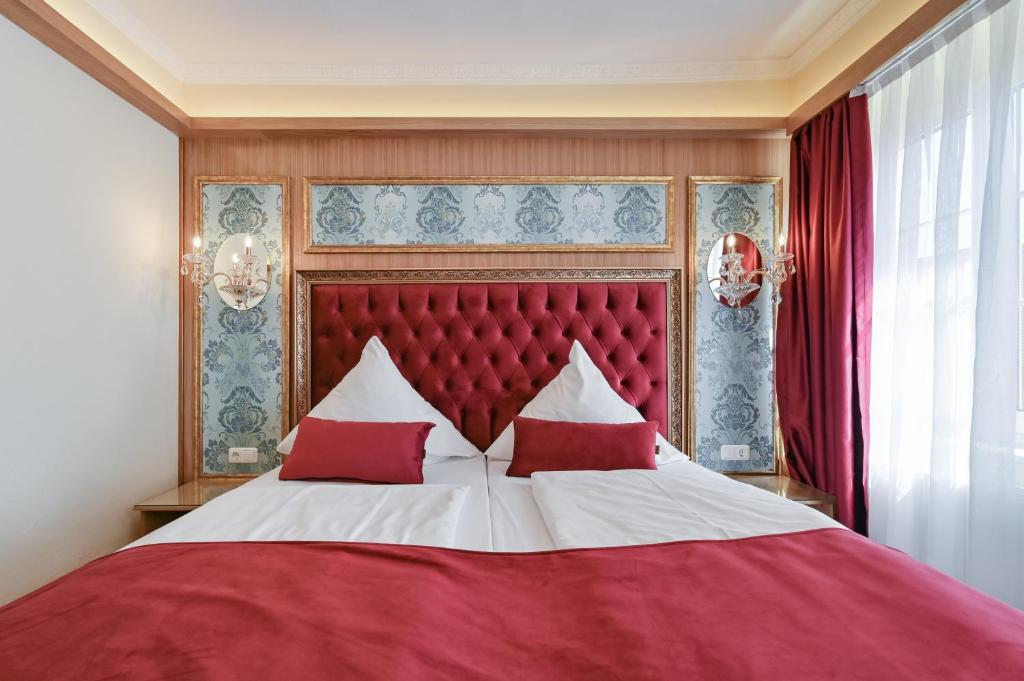 福森路德维格酒店的卧室配有红色和白色的床和红色枕头