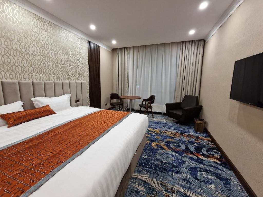 乌兰巴托新西方酒店的一间酒店客房,配有一张床和一台电视