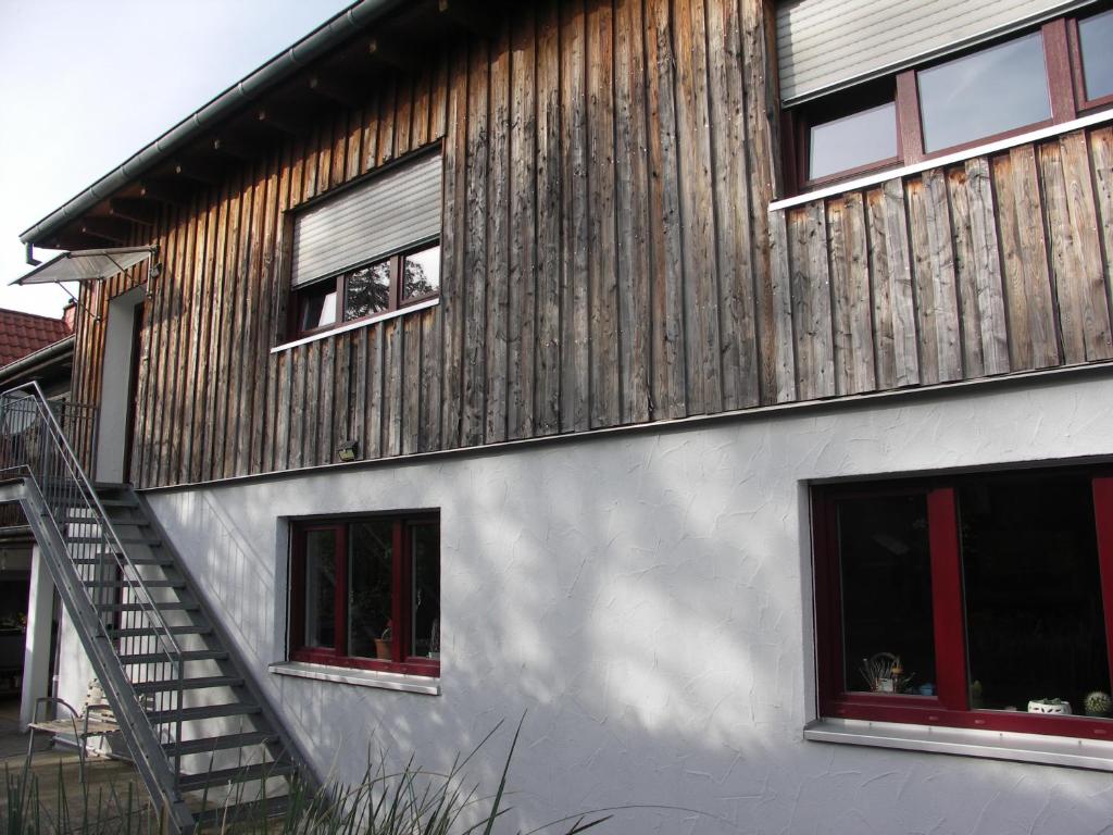 特里尔Ferienwohnung Mattheiser Weiher的一座带木墙和两扇窗户的房子