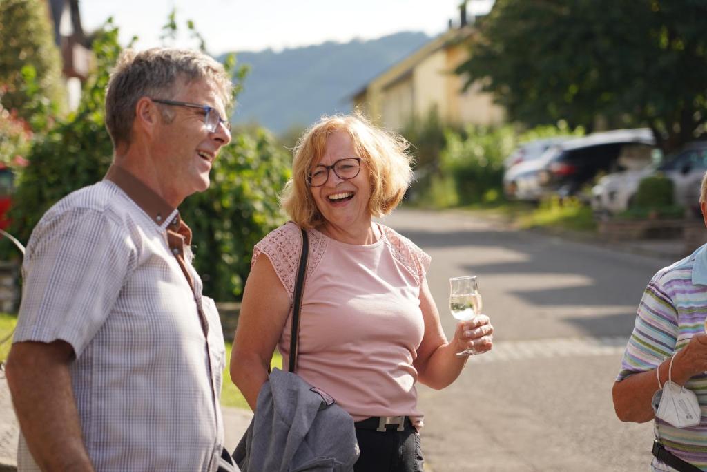 Burg (an der Mosel)Ferienwohnung Rivaner的一位年长男子和一位妇女拿着一杯葡萄酒