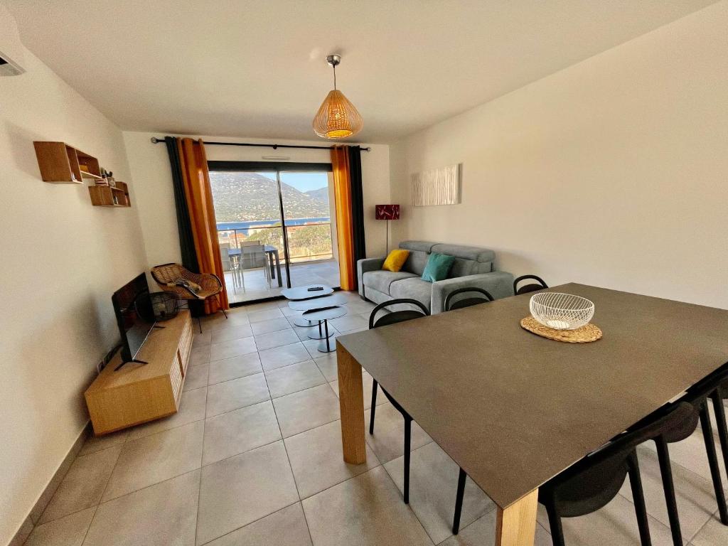 普罗普里亚诺APPART-NEUF-VUE MER- 6 PERS的客厅配有桌子和沙发