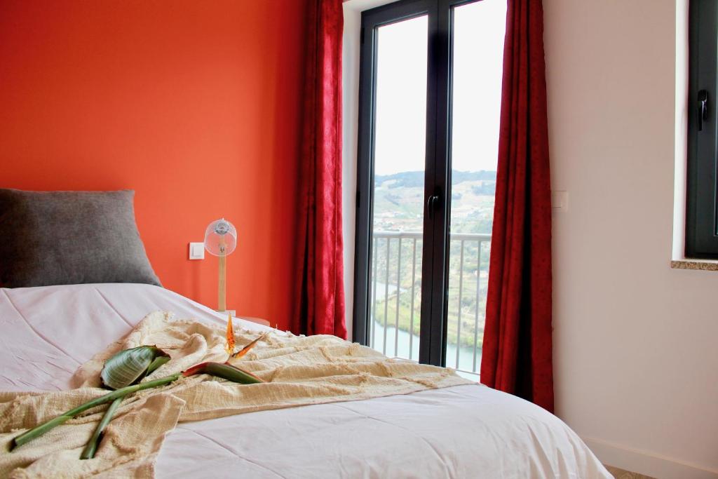 BarrôQuinta do Fojo Valonguinho, Barrô的一间卧室设有橙色的墙壁和一张带窗户的床