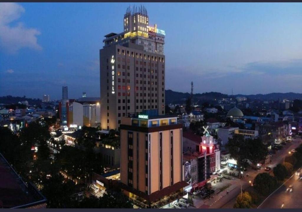 名古屋SOVRANO HOTEL BATAM fka PARKSIDE SOVRANO HOTEL的城市中一座高大的建筑,上面有灯