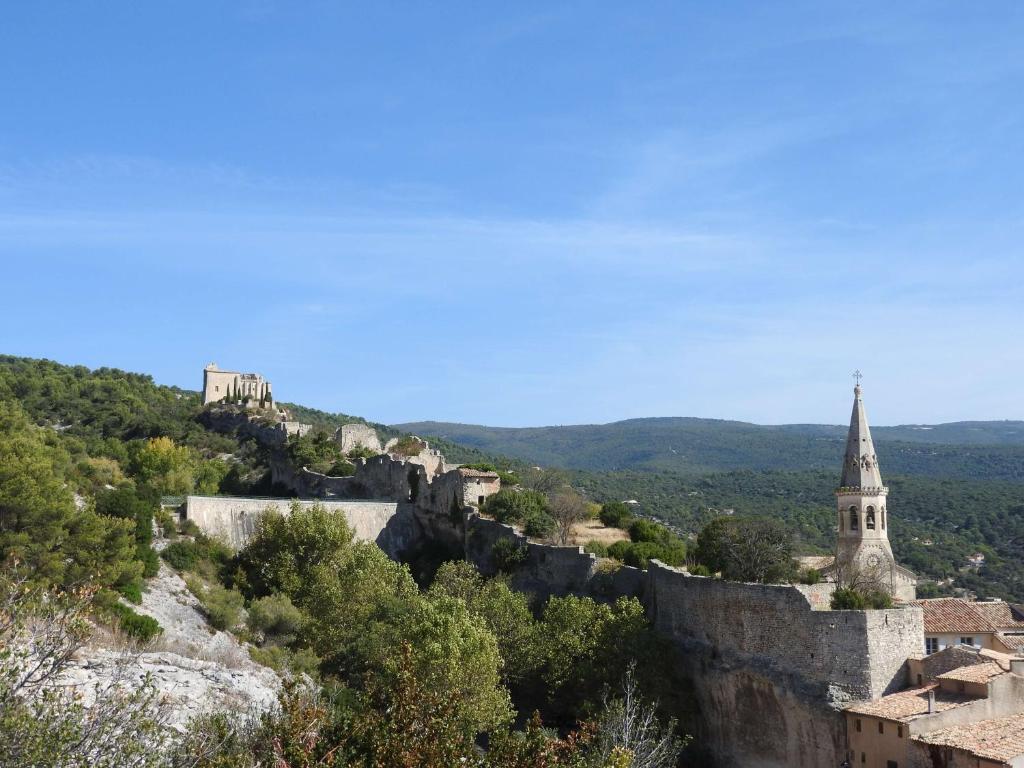 圣萨蒂南艾普特Luberon maison au cœur d'un village provençal的享有城堡和山丘上教堂的景色