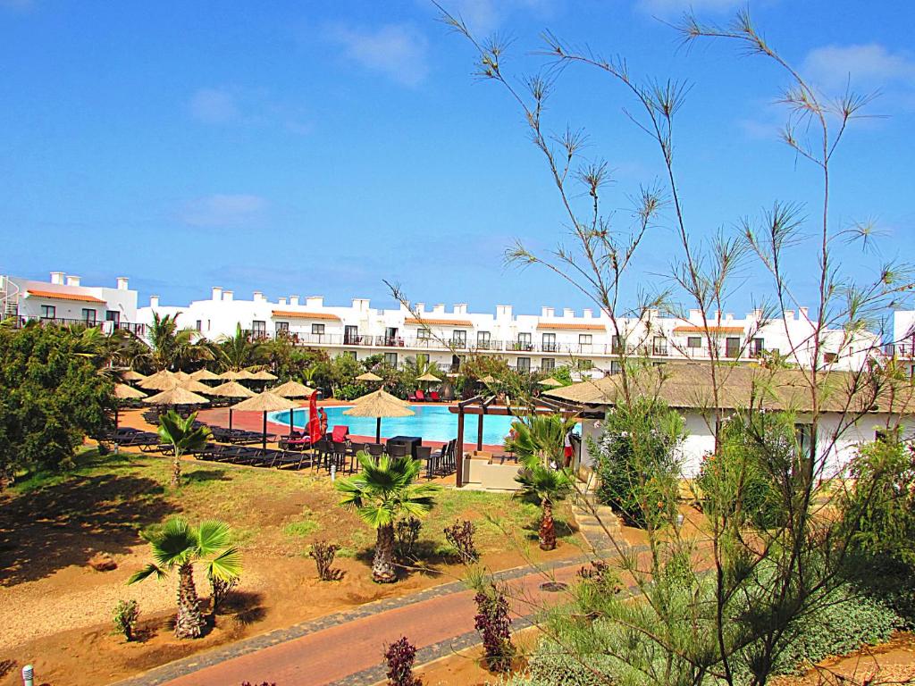 圣玛丽亚BCV - Private Apartments Dunas Resort 1 & 2 Beds的一个带游泳池、桌子和遮阳伞的度假村