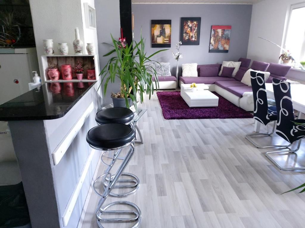 卢布尔雅那Holiday Home Livada的客厅配有紫色的沙发和凳子