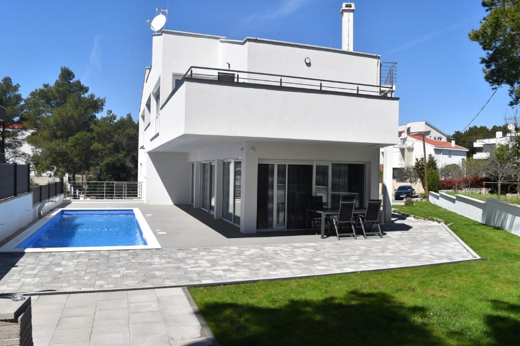 比奥格勒·纳·莫鲁Villa Dalija的一座带游泳池和庭院的白色房子