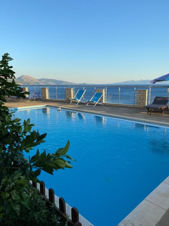 科帕罗Ionian Bay Rooms的一个大型的游泳池,背景是大海