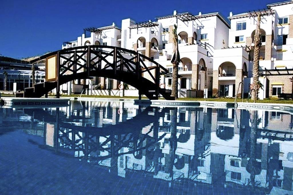 维拉Al-Andalus Thalassa Home Star的一座建筑前的一座水塘和一座桥