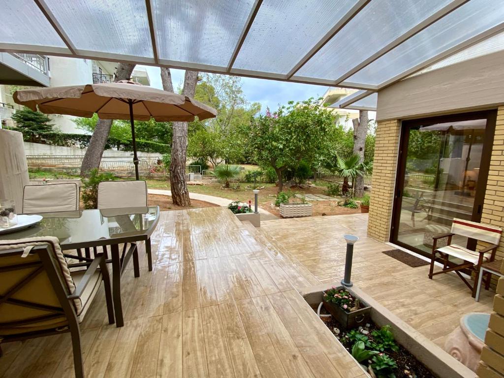 雅典Amazing Garden House的一个带桌子和遮阳伞的庭院