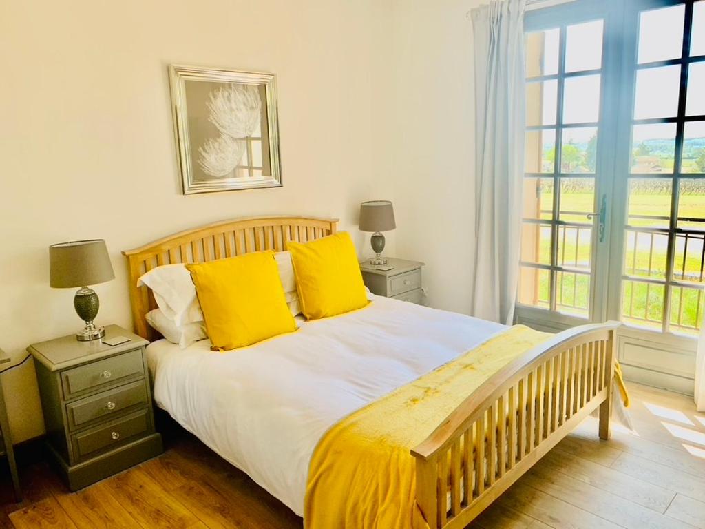 PomportLes Grands Bois的一间卧室配有一张带黄色枕头的大床
