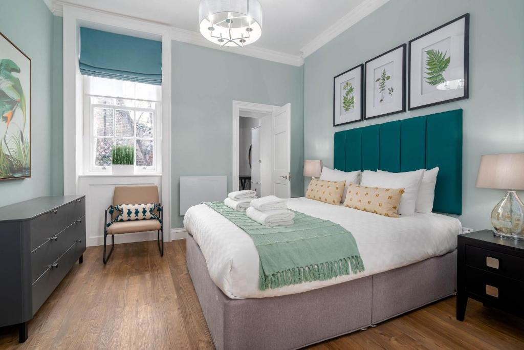 伦敦37 Doughty Street的一间卧室配有一张大床和一把椅子