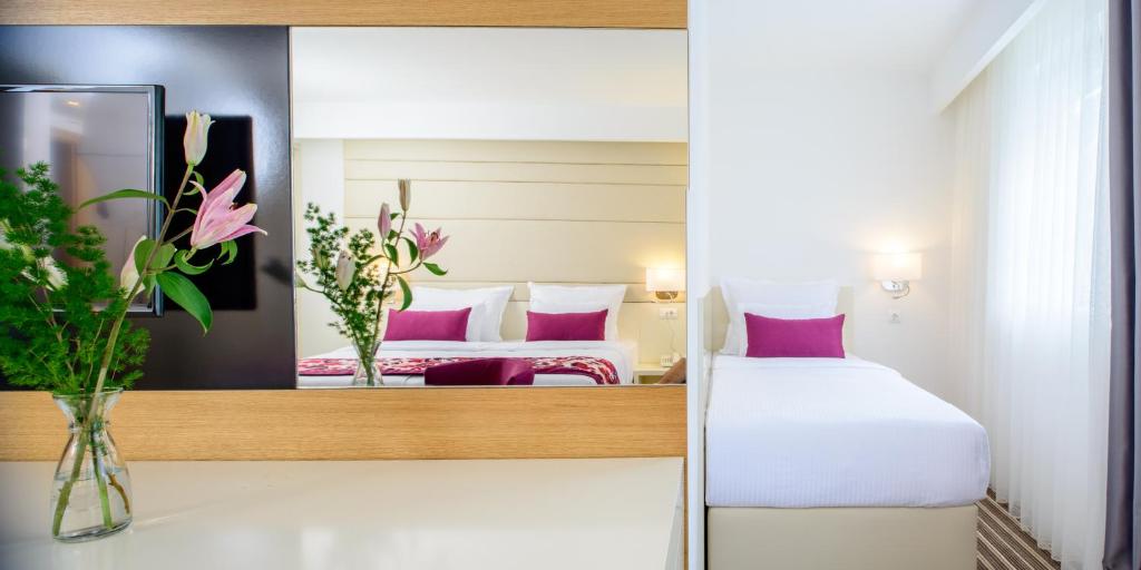萨拉热窝节日酒店的酒店客房,设有两张床和镜子
