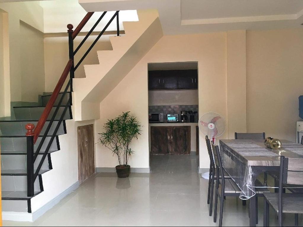 塔比拉兰Kylitas transient house- Bohol的一间带楼梯和餐桌的客厅