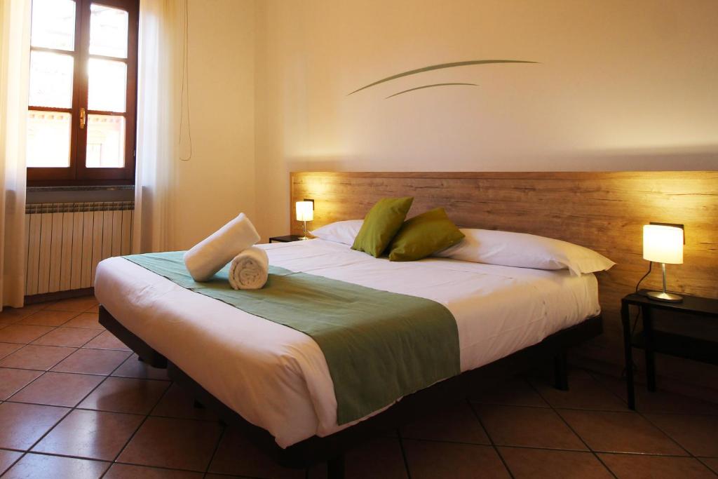 诺瓦拉Hotel Tornielli 9的一间卧室配有一张大床和木制床头板