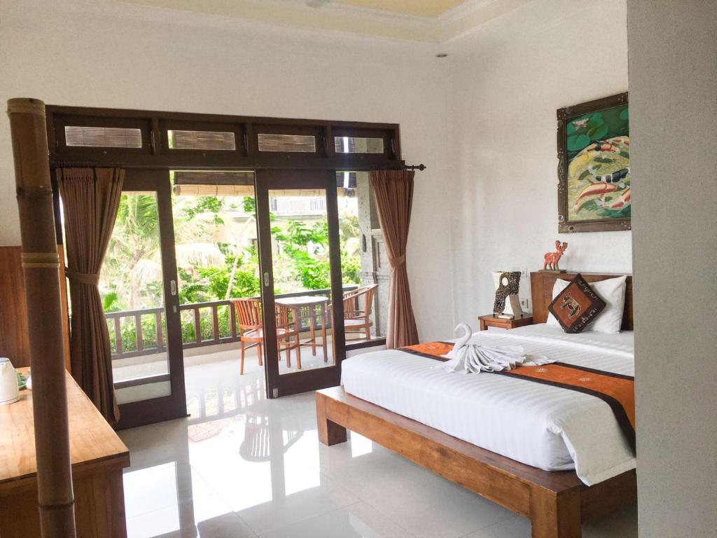乌布Putra Bisma Guesthouse的一间带两张床的卧室和一个阳台