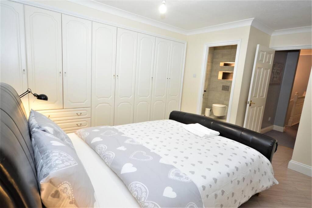 HornchurchLuxury 5 Bedroom House with Free Parking on Site的一间卧室配有一张带白色床罩的床
