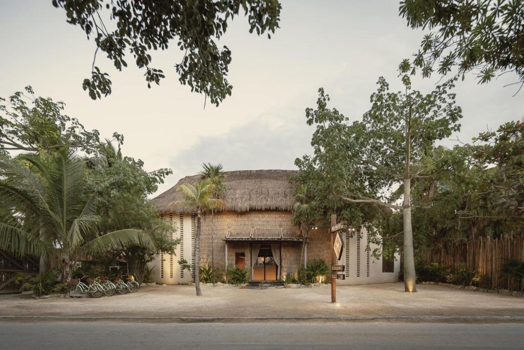 图卢姆Hotel Ma'xanab Tulum的茅草屋顶的大型砖砌建筑