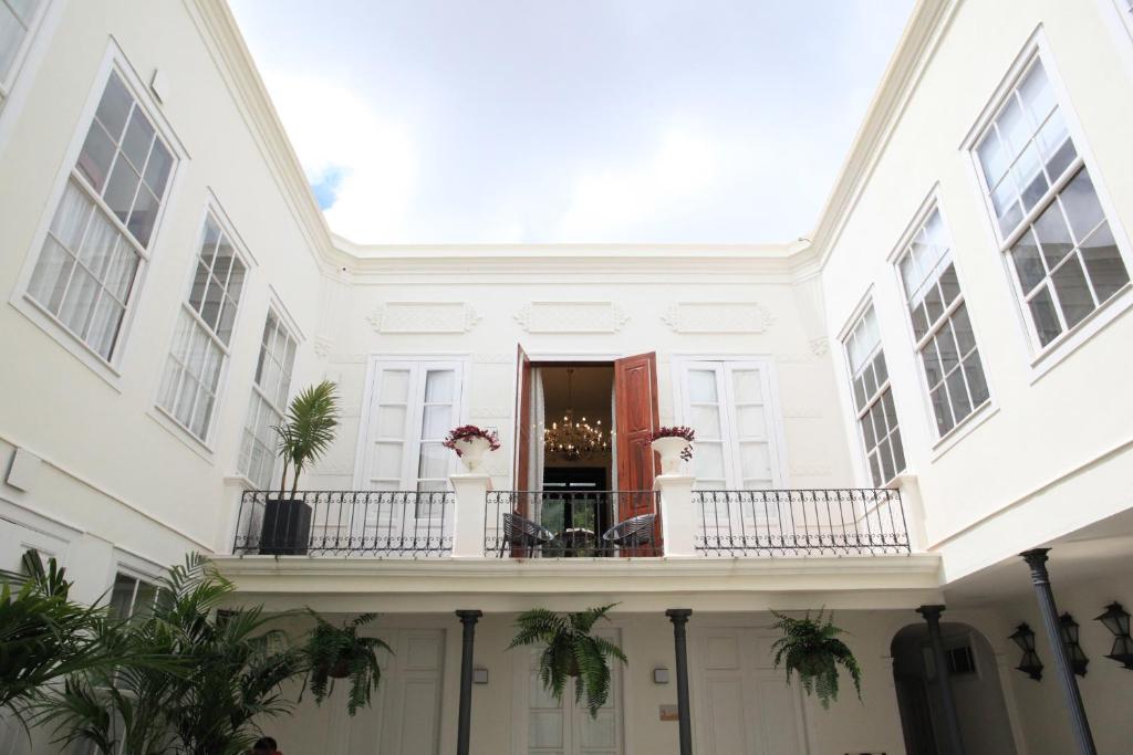 拉拉古纳Nava Suites的带阳台和棕榈树的白色房屋