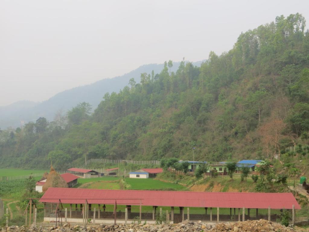 GorkhāGorkha Organic Agro Farm的山丘上的一个小村庄,有红色屋顶
