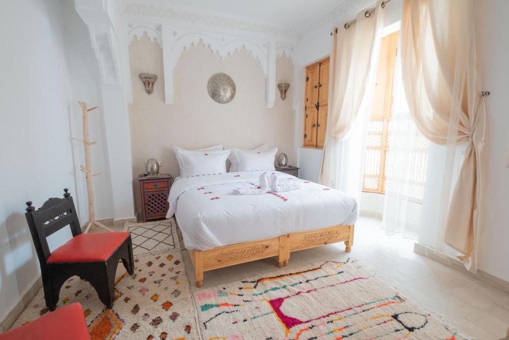 马拉喀什Riad El Habib的卧室配有白色的床和红色椅子