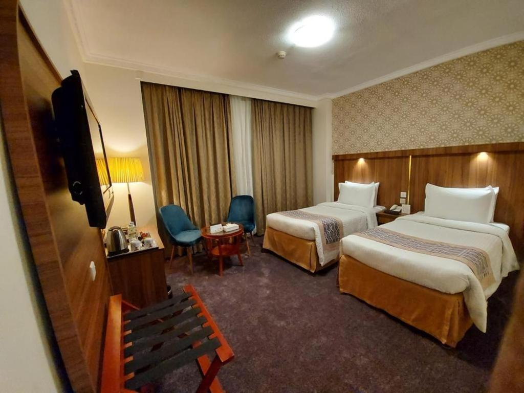 麦地那Saraya Harmony Hotel A的酒店客房设有两张床和电视。