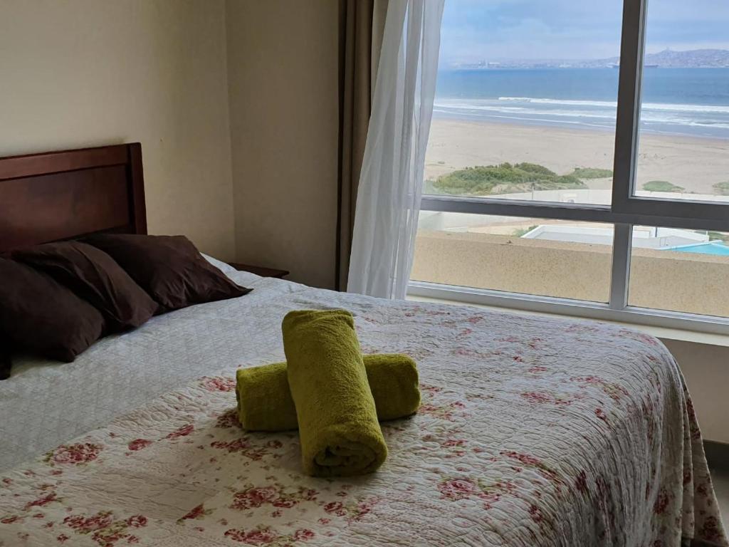 拉塞雷纳DEPARTAMENTO FRENTE AL MAR EN RESORT Laguna del Mar 7P的一间卧室配有一张床,享有海滩美景