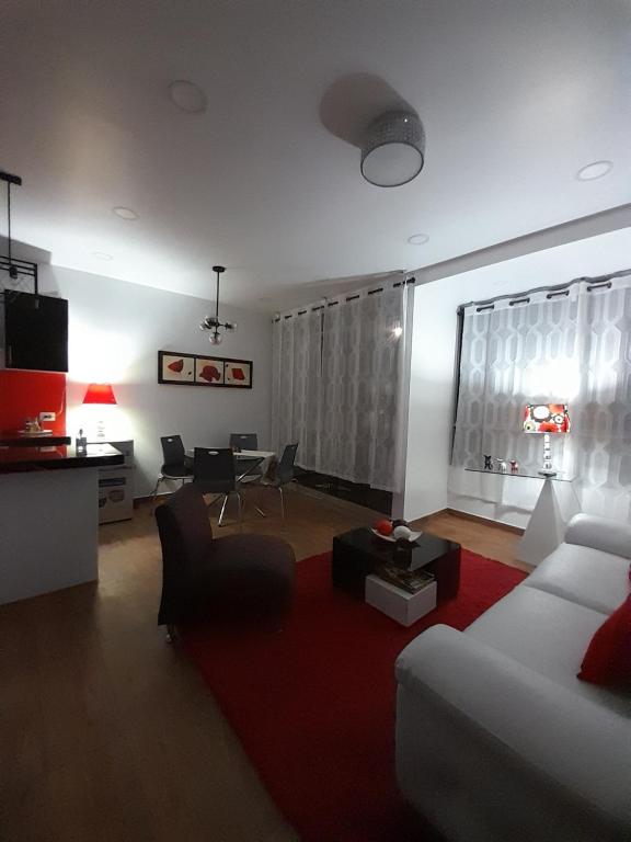 塔克纳Casablanca 2的客厅配有白色沙发和红色地毯。