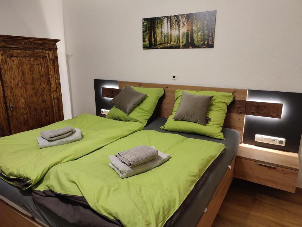 圣沃尔夫冈Studio in einem Bauernhaus的一间卧室配有两张带绿床单和枕头的床。