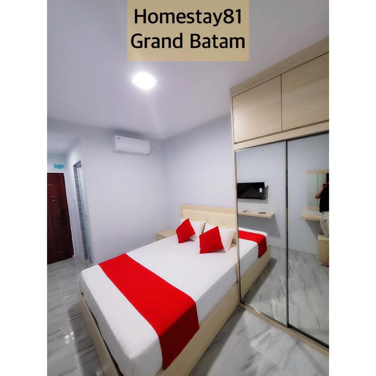 名古屋Homestay 81 Grand Batam的一间卧室配有一张带红白毯子的床