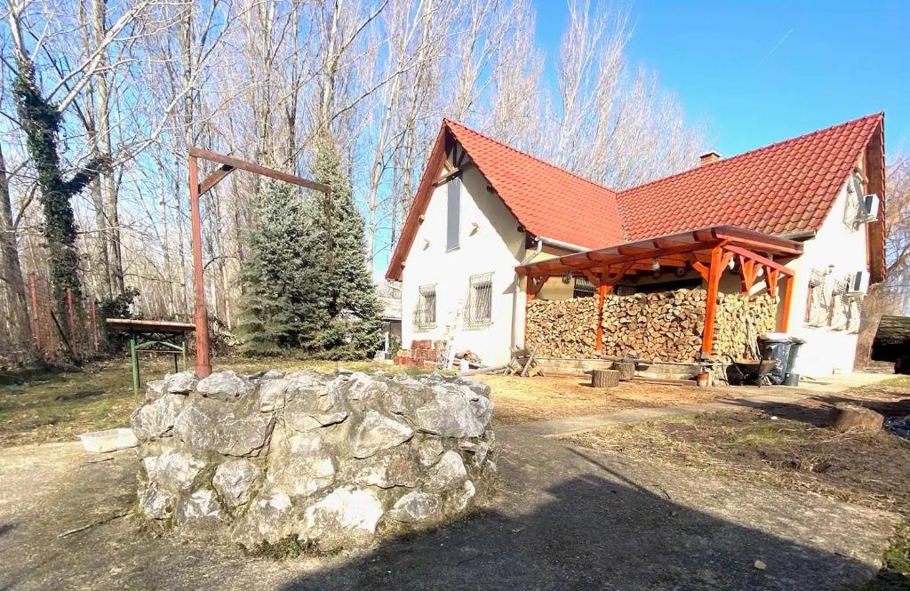 TiszaderzsHarcsáztat-Lak的白色的房子,有红色的屋顶和石墙