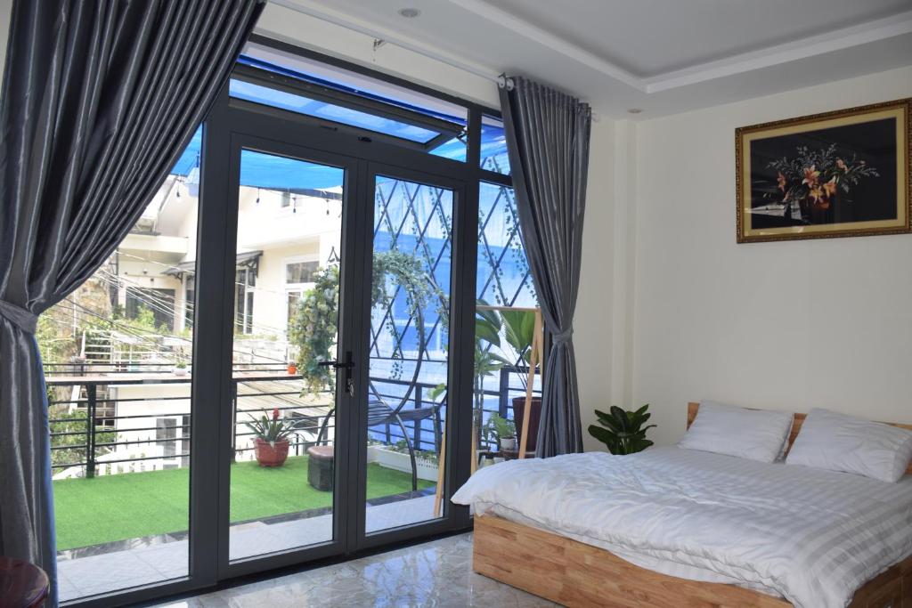 大叻CSLT HÀ THANH TÙNG的一间卧室设有一张床和一个大型玻璃门