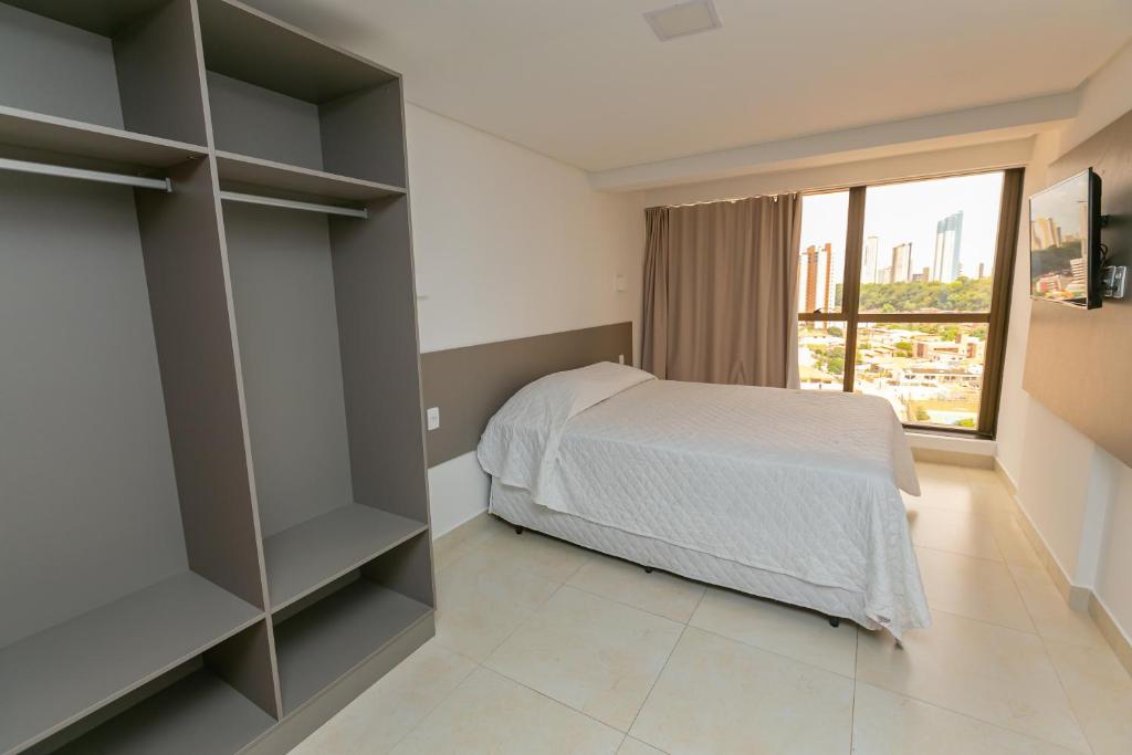 若昂佩索阿Manaíra Apart Flat的一间卧室设有一张床和一个大窗户